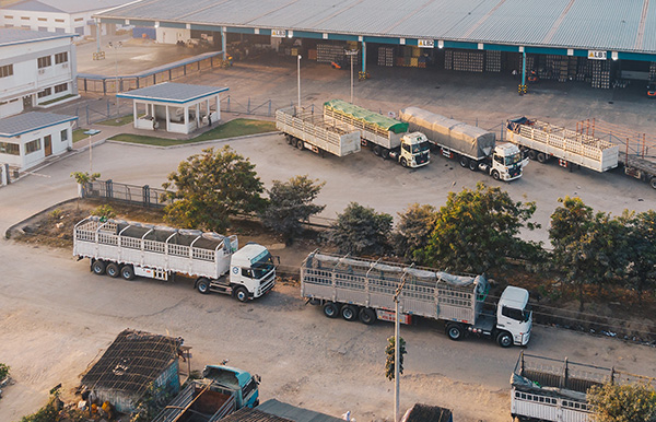 An aerial shot of factory trucks parked near the warehouse at daytime